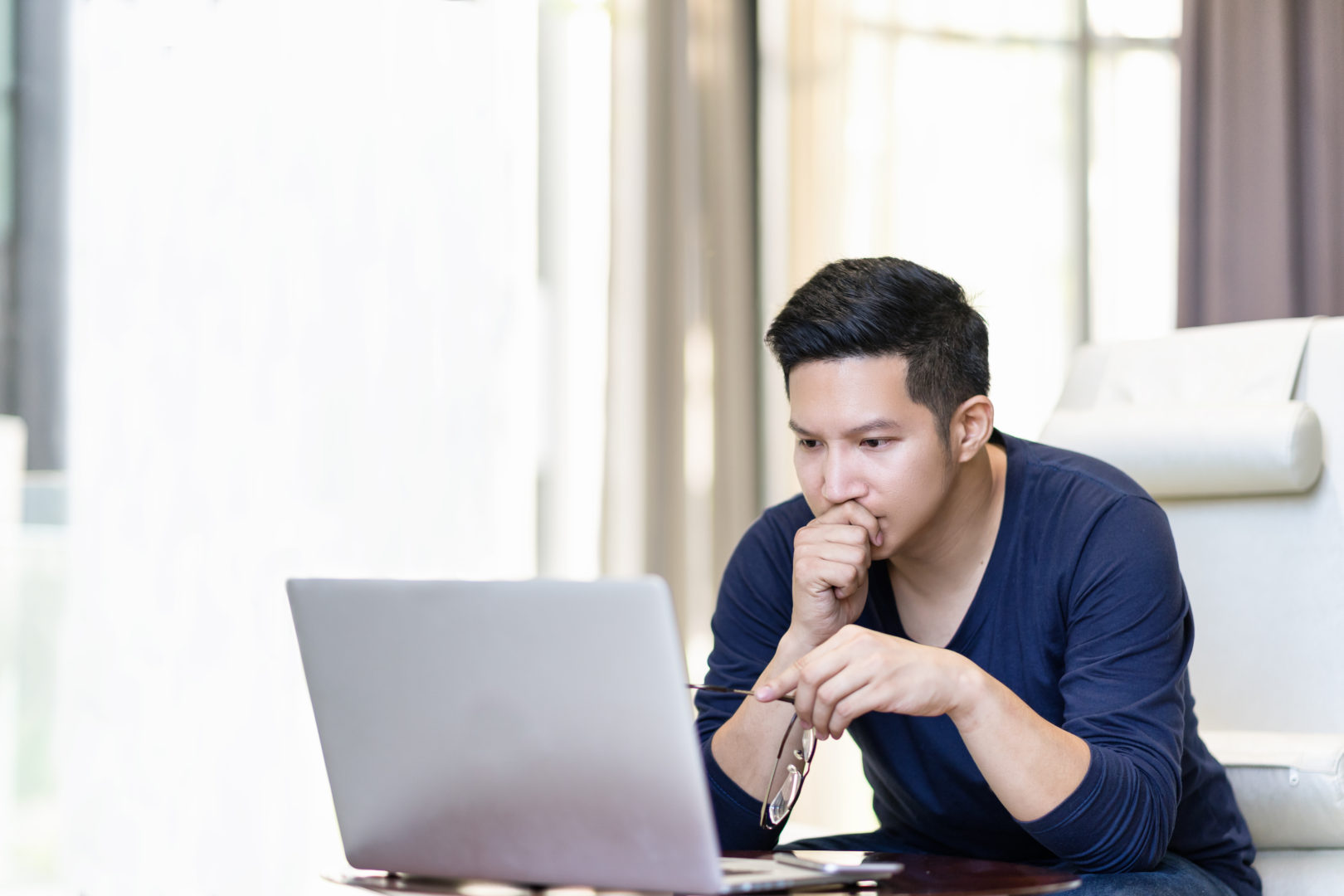 Image of young man using his laptop at home